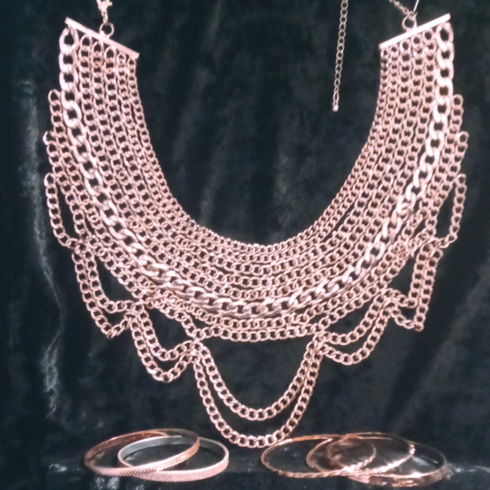 Copper tone statement necklace and bangle bracelets.